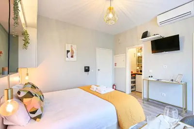 a bedroom with a bed and a tv on the wall at Julio Dinis Porto Secret Retreat - by Guest SPA in Porto