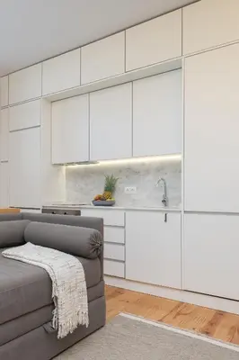 a kitchen with white cabinets and a couch in a room at Host Wise - Refreshing Cozy Flat - Garden & Terrace in Porto