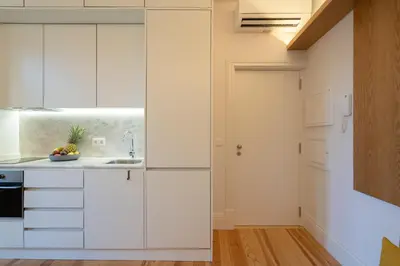 a kitchen with white cabinets and a sink at Host Wise - Refreshing Cozy Flat - Garden & Terrace in Porto