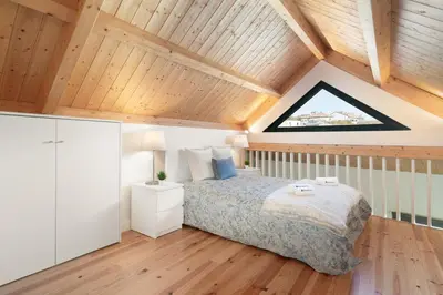 a bedroom with a bed and a wooden ceiling at Host Wise - Lovely & Cozy Duplex Flat in Porto