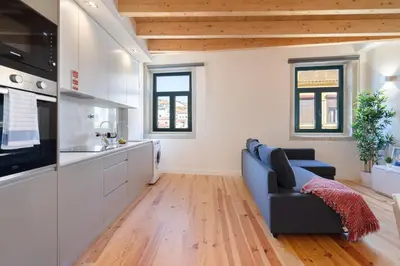 a living room with a blue couch and a kitchen at Host Wise - Lovely & Cozy Duplex Flat in Porto