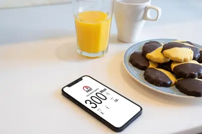 a cell phone sitting next to a plate of cookies and orange juice at Host Wise - Lovely & Cozy Duplex Flat in Porto