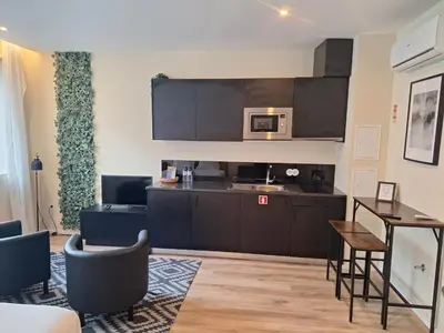 a kitchen with black cabinets and a table and chairs at Lemago Porto Apartments - Bonjardim in Porto