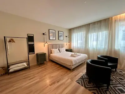a bedroom with a bed and a couch and a chair at Lemago Porto Apartments - Bonjardim in Porto