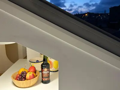 a bowl of fruit and a bottle of alcohol on a ledge at Art Cottage with oPorto View! in Vila Nova de Gaia