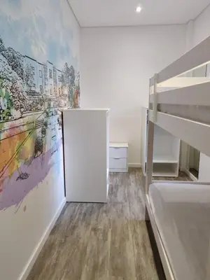 a bedroom with a bed and a painting on the wall at OLOPO Hostel in Porto