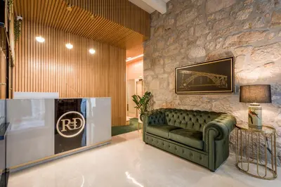 a living room with a green couch and a stone wall at Ribeira Douro Hotel in Porto