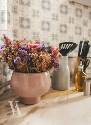 a vase with flowers in it sitting on a counter at Voga Apartments Marquês in Porto
