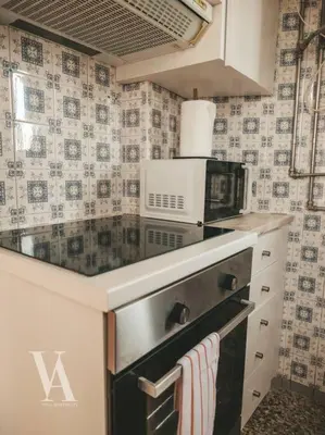 a kitchen with a stove top oven with a microwave at Voga Apartments Marquês in Porto