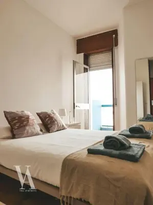 a bedroom with two beds and a large window at Voga Apartments Marquês in Porto