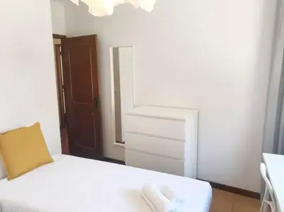 a bedroom with a white bed and a dresser at Covelo 90 in Porto