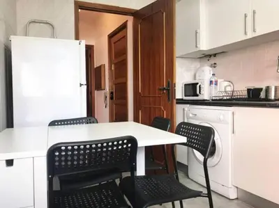 a kitchen with a white table and chairs at Covelo 90 in Porto