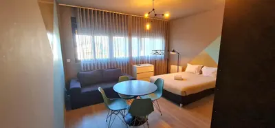a small room with a bed and a table and chairs at Dragon Studio in Porto