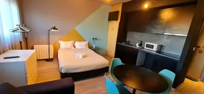 a small room with a bed and a table at Dragon Studio in Porto