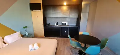 a small room with a table and a kitchen at Dragon Studio in Porto