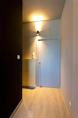 a hallway with a large door with a light on it at Dragon Studio in Porto