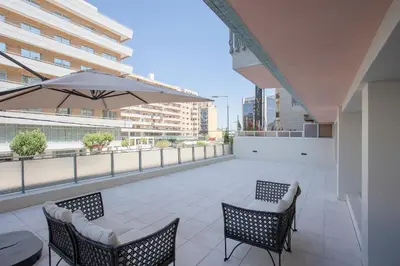 a balcony with two chairs and a table and an umbrella at Allegro Boutique Apartments by Liiiving in Porto