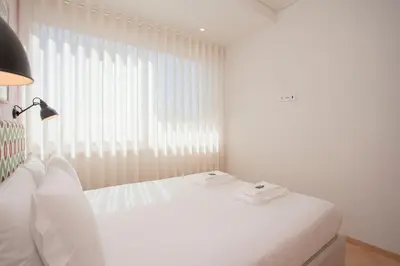 a white bedroom with a white bed and a window at Allegro Boutique Apartments by Liiiving in Porto