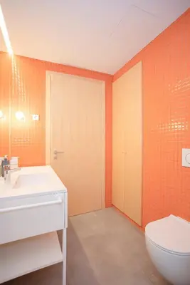 an orange bathroom with a sink and a toilet at Allegro Boutique Apartments by Liiiving in Porto