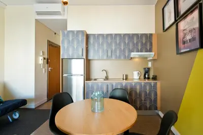 a dining room with a table and a refrigerator at Trindade City Studio 77 in Porto