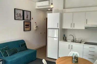 a kitchen with a blue couch and a white refrigerator at Trindade City Studio 77 in Porto