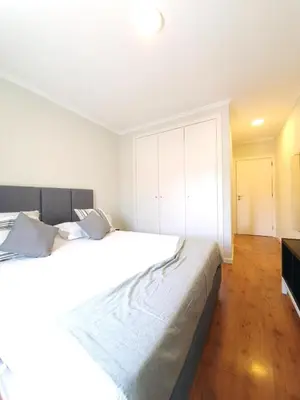a bedroom with a large white bed with a cabinet at Sonetos - Guest House in Porto