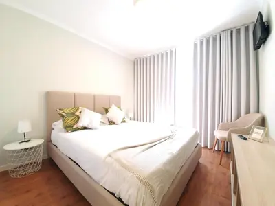 a white bedroom with a bed and a window at Sonetos - Guest House in Porto