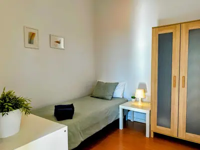a small bedroom with a bed and a table at Figueiroa 10 in Porto