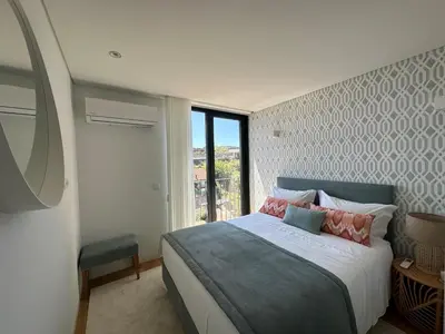 a bedroom with a large bed and a window at BONFIM LIVING - Great location, al fresco dining and free private parking in Porto