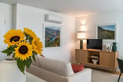 a living room with a couch and a vase of sunflowers at BONFIM LIVING - Great location, al fresco dining and free private parking in Porto