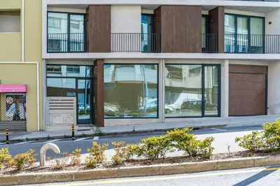 a building with glass windows on a city street at BONFIM LIVING - Great location, al fresco dining and free private parking in Porto