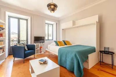 a bedroom with a bed and a blue chair at D&S - Palácio dos Príncipes in Porto