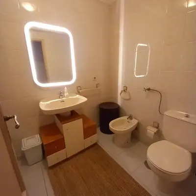 a white bathroom with a toilet and a sink at Apartment with Private Garden in Porto