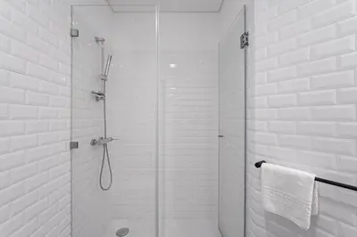 a bathroom with a shower with a glass door at GuestReady - Tranquility in downtown in Porto