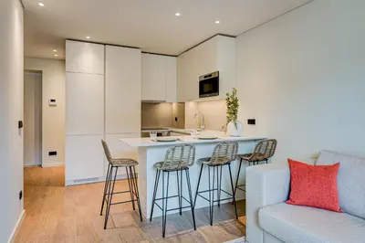 a kitchen and living room with a counter and stools at Blissful Suites Porto by gaiarooms in Porto