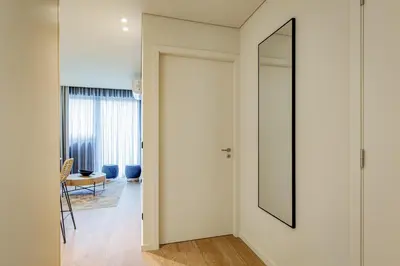 a hallway with a mirror next to a door at Blissful Suites Porto by gaiarooms in Porto