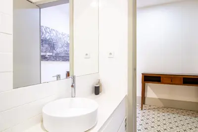 a white bathroom with a sink and a mirror at Central Stunning Duplex w/ Patio by LovelyStay in Porto