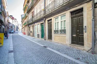 a wooden table and chairs sitting on a balcony at Central Stunning Duplex w/ Patio by LovelyStay in Porto