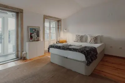 a bedroom with a large bed and a large window at Papa Apartment with Terrace in Porto