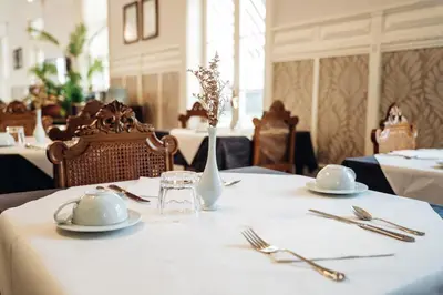 a table with plates and utensils on a white table cloth at GRANDE HOTEL PARIS by STAY HOTELS in Porto