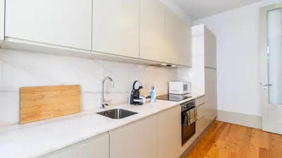a white kitchen with a sink and a microwave at Formosa Delight by LovelyStay in Porto