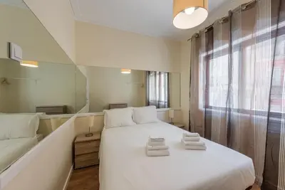 a bedroom with a large white bed and a mirror at GuestReady - October Tide in Porto
