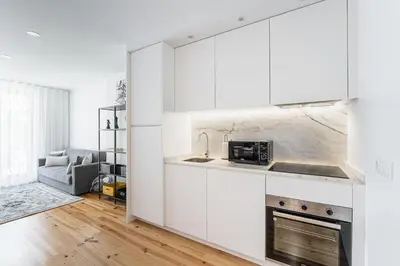 a white kitchen with a sink and a stove at GuestReady - Serene stay in Porto in Porto