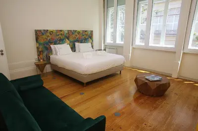 a bedroom with a bed and a couch and a table at Nº 91 - Almirante Guest House in Porto