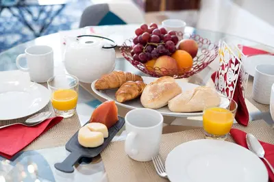 a table with a plate of food and a bowl of fruit at Porto's Legacy by Upperground in Porto