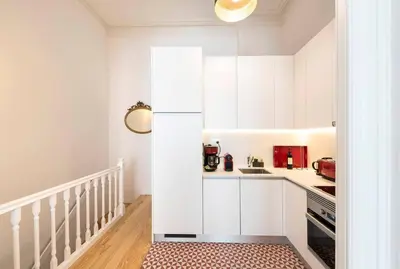 a small kitchen with white cabinets and a rug at Porto's Legacy by Upperground in Porto