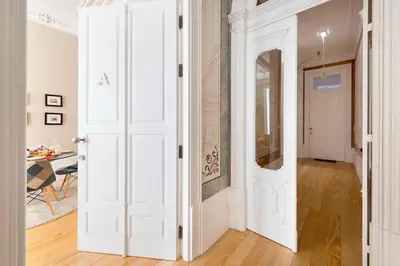 a hallway with a white door and a table at Porto's Legacy by Upperground in Porto