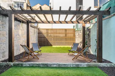 two lounge chairs on a wooden deck with grass at Soho Porto in Porto
