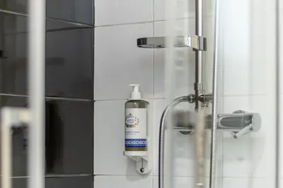 a bathroom with a bottle of soap on the wall at Soho Porto in Porto