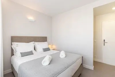 a white bedroom with a large bed with white pillows at Soho Porto in Porto